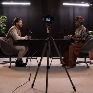 Dynamic podcast session featuring two hosts with studio lighting and recording equipment.