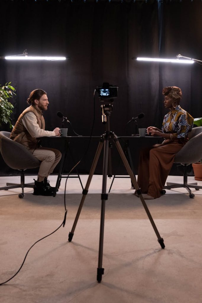 Dynamic podcast session featuring two hosts with studio lighting and recording equipment.